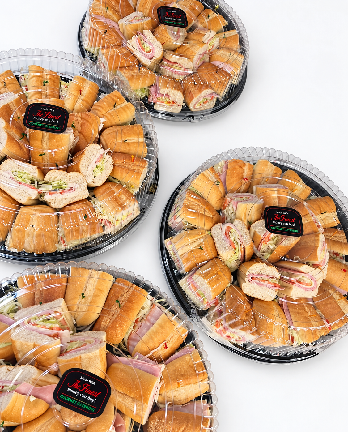 Catering platters filled with assorted deli sandwiches